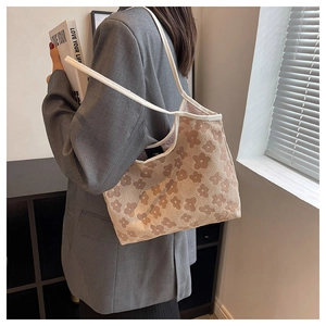 Close-up of floral canvas tote bag with brown flower patterns and slim leather handles