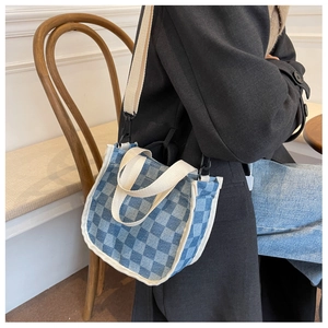 Détail du petit sac seau en toile à damier bleu et blanc avec bandoulière amovible
