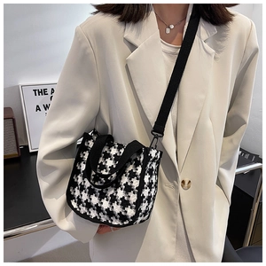 Gros plan du sac à main en toile à motif pied-de-poule avec bandoulière noire