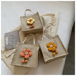 Detailed texture of natural jute tote bags with 3D fabric flower decor and rope handles