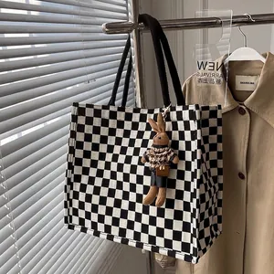 Large checkerboard canvas tote bag with bunny pendant and black woven handles