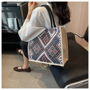 Detail of woven ethnic geometric pattern tote bag featuring durable jute canvas texture