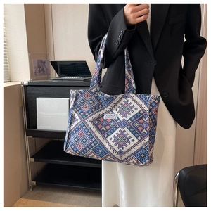 Close-up of ethnic tote bag showing woven geometric patterns and broad shoulder strap