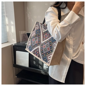 Ethnic embroidered tote bag with jute side detail and black strap on female model