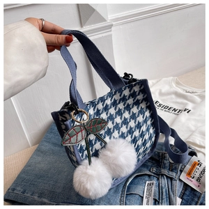 Détail du sac en toile pied-de-poule bleu et blanc avec pendentif cerise en peluche