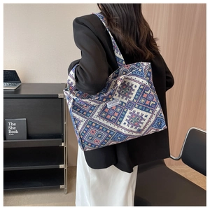 Ethnic geometric pattern tote bag shown over the shoulder of a model in a modern room