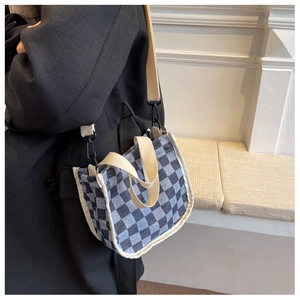 Détail du sac seau en toile à damier bleu avec bandoulière réglable et poignées