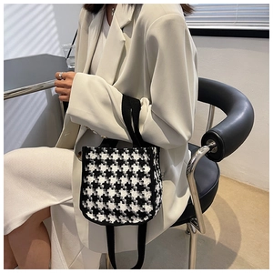 Sac cabas en toile à motif pied-de-poule chic avec poignées noires porté par un mannequin