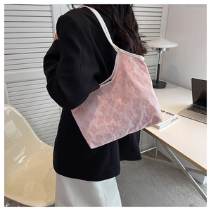 Close-up of a pink floral canvas tote bag featuring embossed flower patterns and white trim