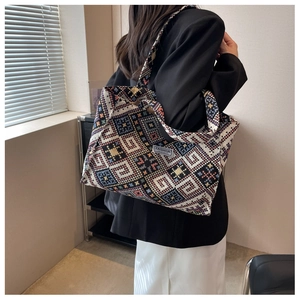 Detailed close-up of ethnic woven tote bag featuring geometric patterns and shoulder strap