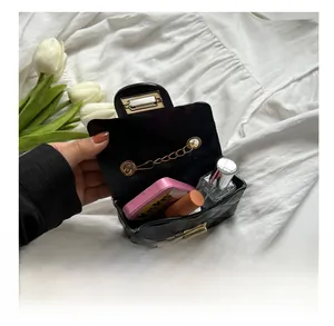 Internal capacity of mini black quilted chain bag with cosmetics and floral accents