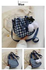 Détails du sac cabas en toile pied-de-poule bleu avec pompons blancs et pendentif de feuille