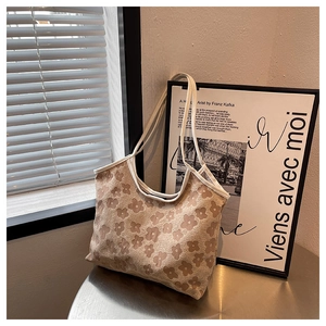 Detailed view of large tote bag featuring textured floral embroidery and contrast straps