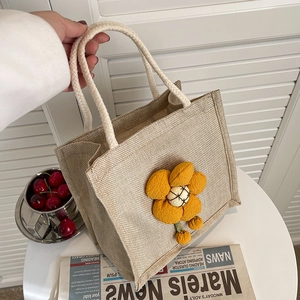 Linen lunch bag with yellow fabric flower and woven handles for commute and picnic