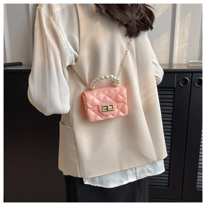 Detail view of pink quilted jelly bag featuring pearl handle and gold chain strap