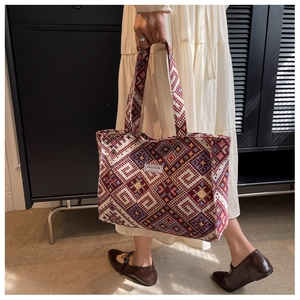 Detailed view of woven ethnic tote bag featuring intricate colorful geometric patterns