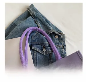 Close-up of durable purple canvas tote bag with reinforced thick woven handles for comfort