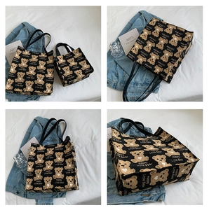 Detail view of canvas tote bags with bear print and black leather handles in two sizes