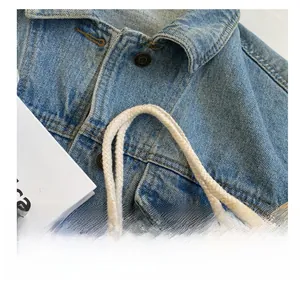 Nahaufnahme der beigen Leinen-Lunchtasche mit dicken Seilgriffen und blauem Denim-Stoff