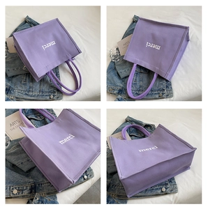 Detailed close-up of purple canvas tote bag with white merci lettering in various angles