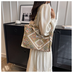 Detailed close-up of a large ethnic knit tote bag with colorful geometric floral patterns