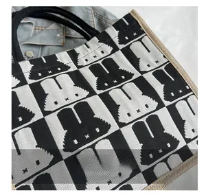 Close-up of the woven canvas texture and pixelated rabbit checkerboard pattern on the tote bag