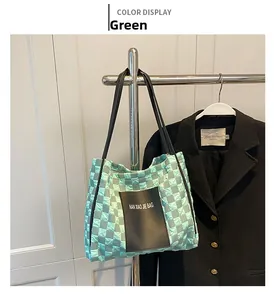 Detail of mint green quilted checkerboard tote bag with black leather shoulder straps
