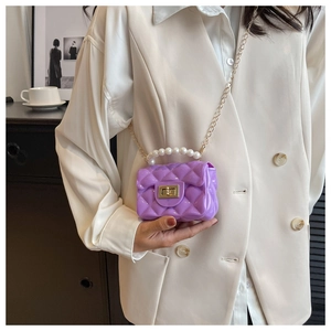 Macro shot of purple quilted jelly mini bag with pearl handle and golden chain strap