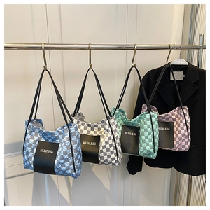 Close-up of quilted checkerboard tote bags in blue, grey, green, and pink colors