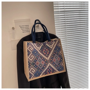 Close-up of geometric ethnic pattern weaving and navy rope handle on a large tote bag