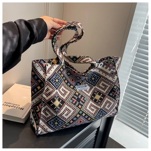Macro shot of ethnic woven tote bag featuring geometric patterns and white label