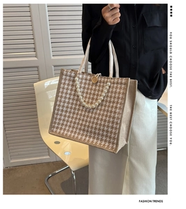 Detail of canvas houndstooth tote bag featuring pearl chain and wood button accents