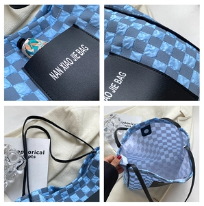 Close-up of blue checkerboard bubble fabric tote bag with leather pocket and magnetic clasp