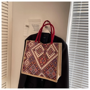 Detail of colorful geometric ethnic pattern woven tote bag with red braided handles