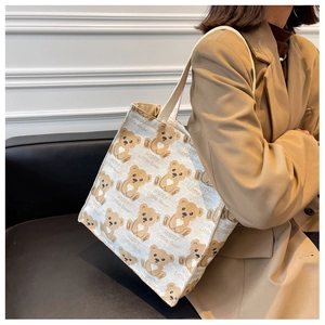 Detail shot of canvas tote bag featuring all-over cartoon bear print and roomy interior