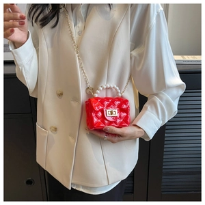 Detail of red quilted mini jelly bag featuring pearl handle and gold chain strap