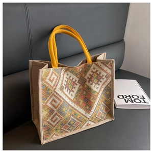 Ethnic style tote bag with mustard yellow handles and geometric pattern fabric detail