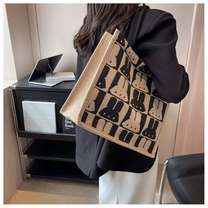 Minimalist checkerboard tote bag with pixel rabbit pattern shown on model's shoulder