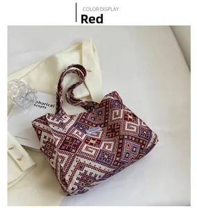 Close-up of ethnic woven tote bag with red geometric patterns and fashion label