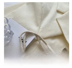 Detailed close-up of woven cotton rope handles with white lace trim on a linen handbag