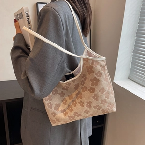Floral print canvas tote bag with a soft knit texture shown in a casual lifestyle setting