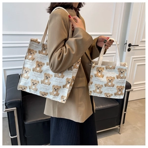 Detail view of small and large canvas bags with happy little bear cartoon prints