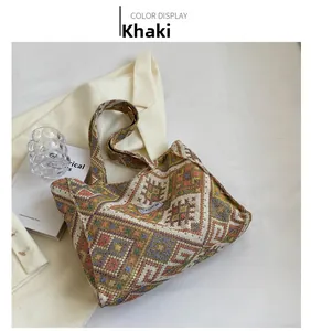 Detail view of khaki ethnic geometric woven tote bag with a fashion logo tag