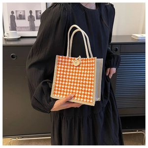 Dettaglio della borsa tote in lino pied-de-poule arancione con grande bottone in legno