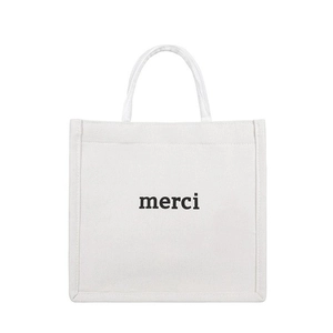 Minimalist white canvas tote bag with black merci print and sturdy dual handles