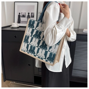 Detail of pixel rabbit tote bag with blue checkerboard canvas and shoulder strap