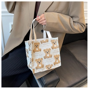 Detail of canvas tote bag featuring cute cartoon bear print and Happy Little Bear text
