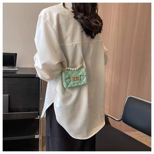 Detail of mint green quilted mini jelly bag with pearl handle and golden chain