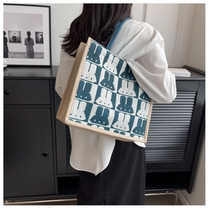 Detailed view of checkered tote bag with cartoon pattern on model's shoulder