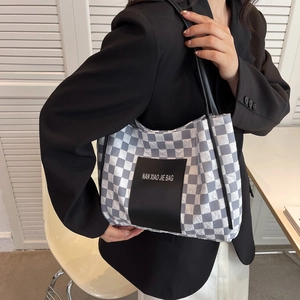 Blue and white checkerboard tote bag with bubble texture and black leather handles